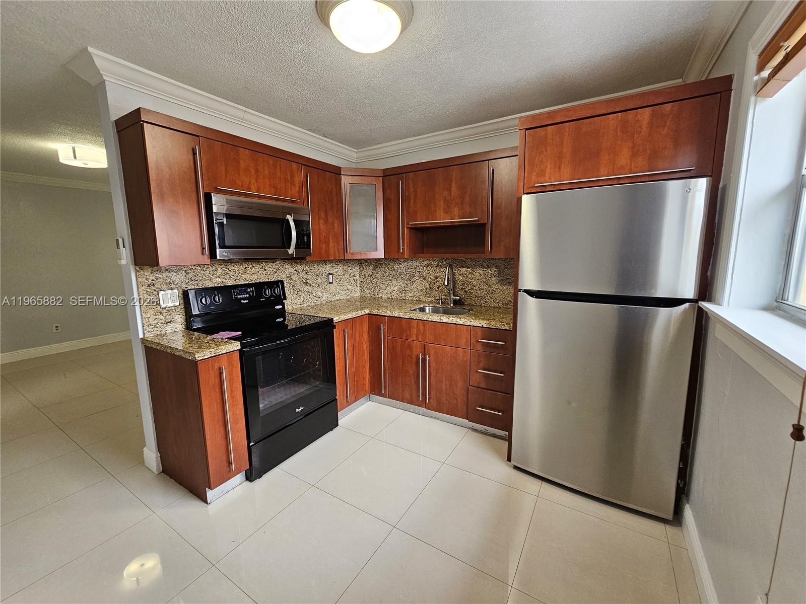 47 Northwest 47th Avenue, Unit 16 Miami, FL 33126 - Photo 1 of 10 a kitchen with stainless steel appliances granite countertop a refrigerator stove a sink dishwasher and microwave