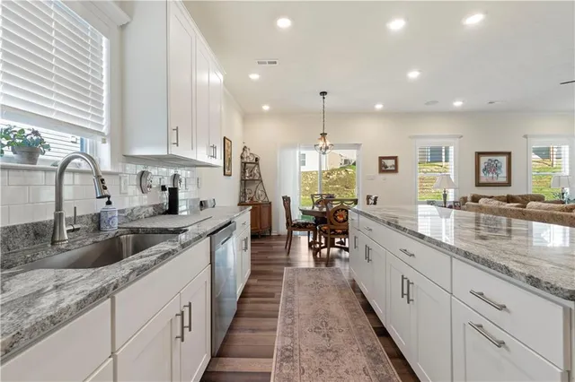 a large kitchen with granite countertop lots of counter space a sink and appliances