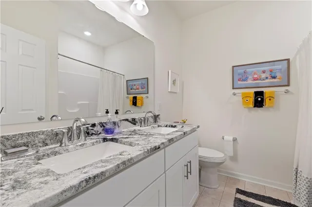 a bathroom with a granite countertop sink mirror vanity and toilet