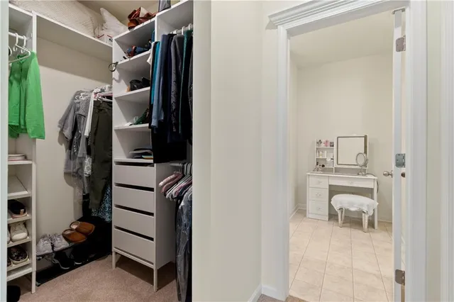 a view of walk in closet with clothes and shoes