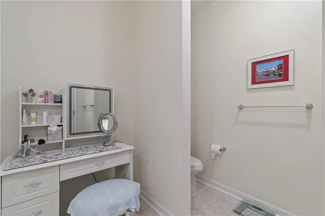 a bathroom with a granite countertop toilet sink and mirror