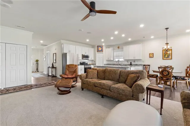 a living room filled with furniture and kitchen view