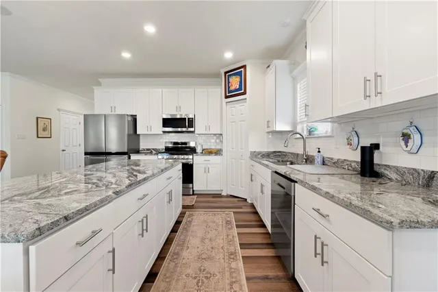 a large kitchen with stainless steel appliances granite countertop a stove sink and cabinets