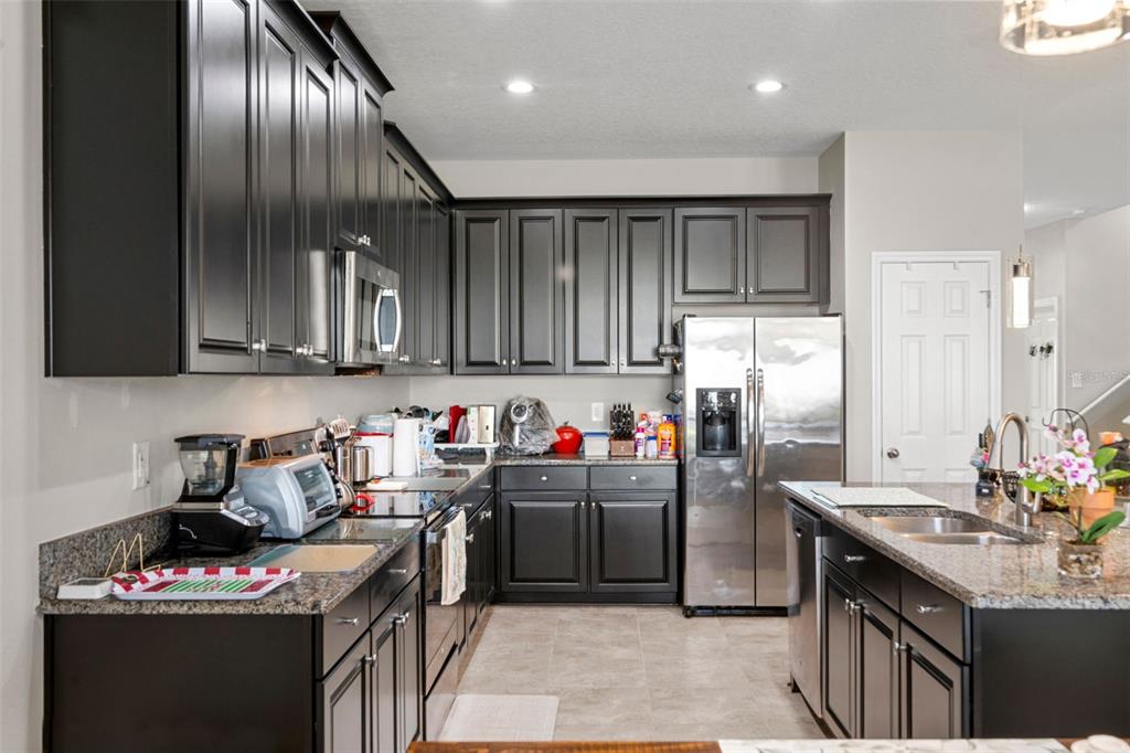 18565 Obregan Drive Spring Hill, FL 34610 - Photo 19 of 70 a kitchen with stainless steel appliances granite countertop a sink a stove and a refrigerator