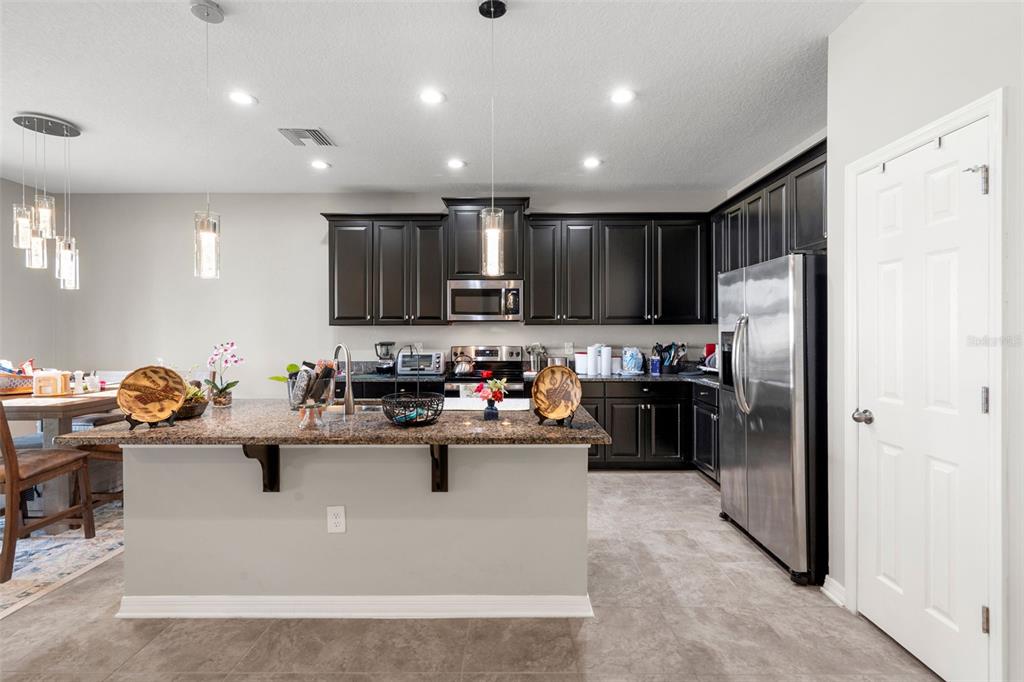 18565 Obregan Drive Spring Hill, FL 34610 - Photo 20 of 70 a kitchen with kitchen island stainless steel appliances cabinets a sink and a refrigerator