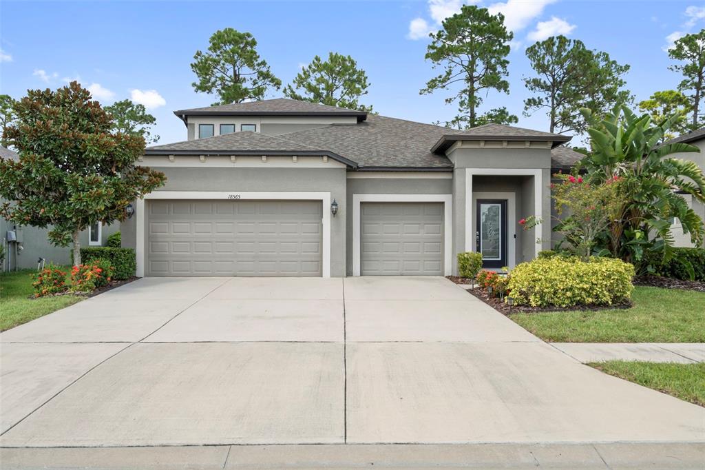 18565 Obregan Drive Spring Hill, FL 34610 - Photo 2 of 70 a front view of a house with a garden and plants