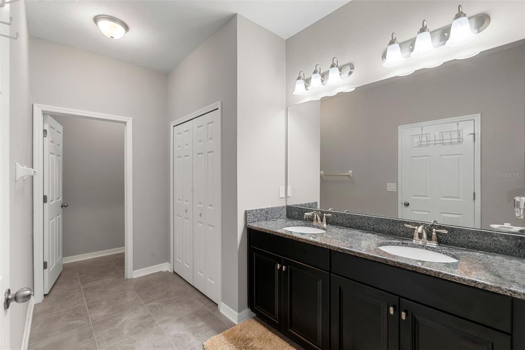 18565 Obregan Drive Spring Hill, FL 34610 - Photo 27 of 70 a bathroom with double vanity sinks and a mirror