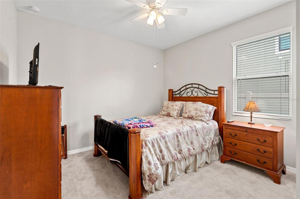 18565 Obregan Drive Spring Hill, FL 34610 - Photo 32 of 70 a bedroom with a bed and a chandelier