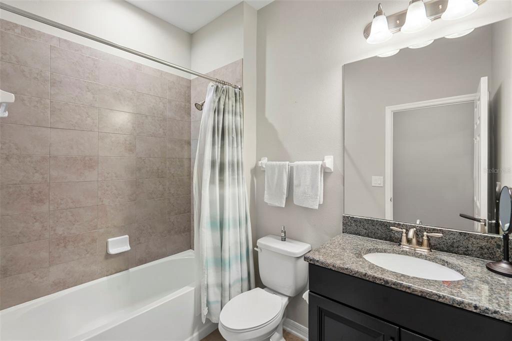 18565 Obregan Drive Spring Hill, FL 34610 - Photo 36 of 70 a bathroom with a granite countertop sink toilet a mirror and shower