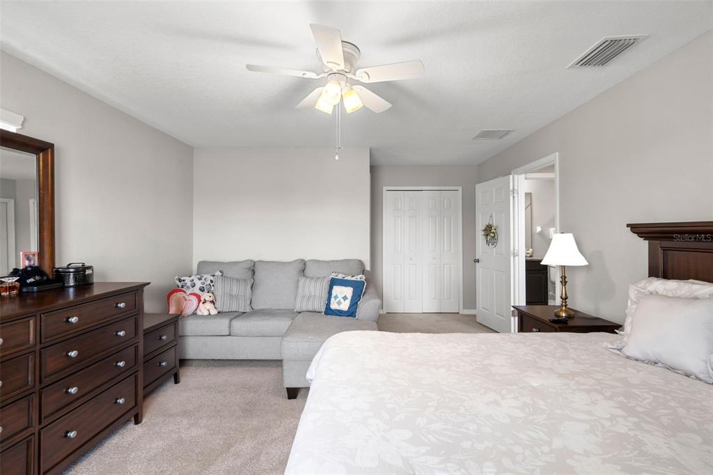 18565 Obregan Drive Spring Hill, FL 34610 - Photo 44 of 70 a bedroom with a bed and a chandelier