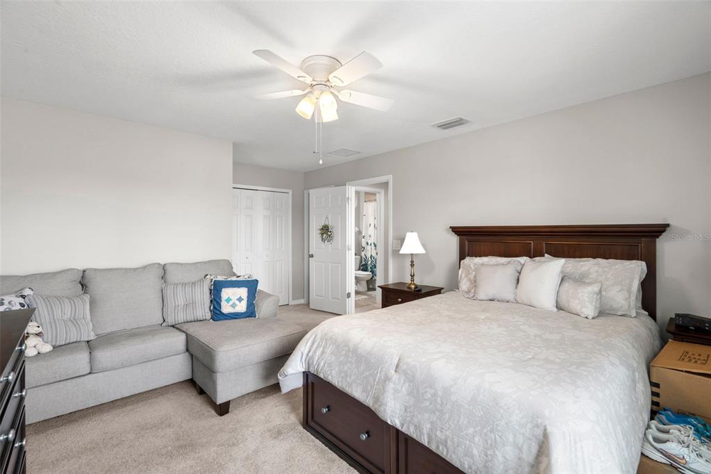 18565 Obregan Drive Spring Hill, FL 34610 - Photo 45 of 70 a spacious bedroom with a bed and couch