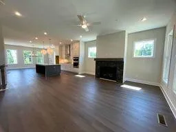 a living room with wooden floor a fireplace and a window