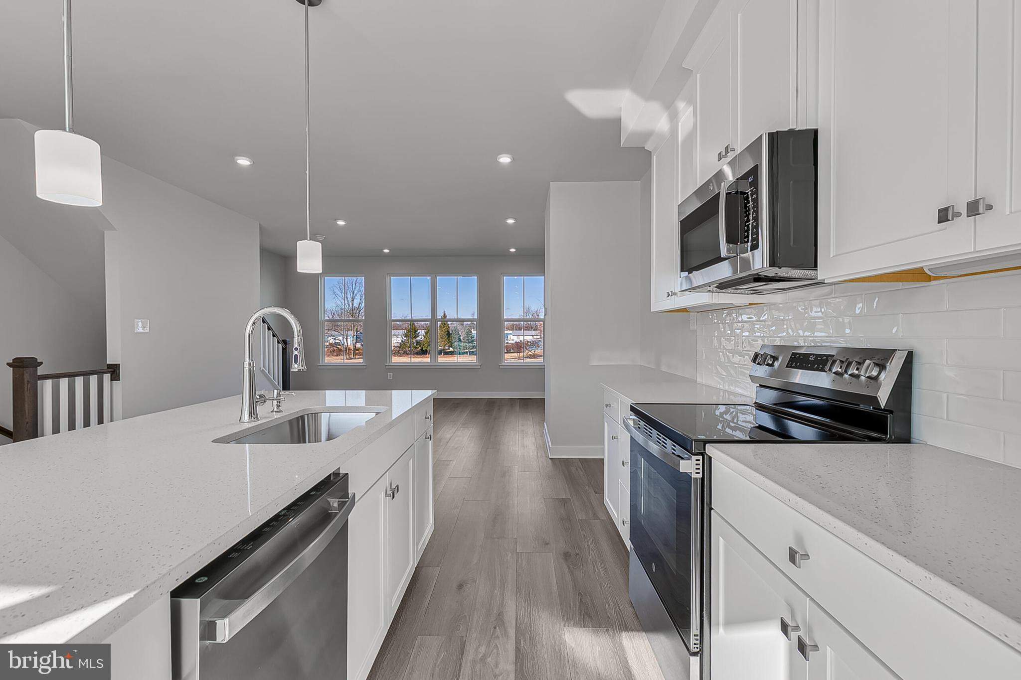 33 B Oasis Avenue Ranson, WV 25438 - Photo 12 of 38 a kitchen with stainless steel appliances granite countertop a sink a stove and a wooden floors