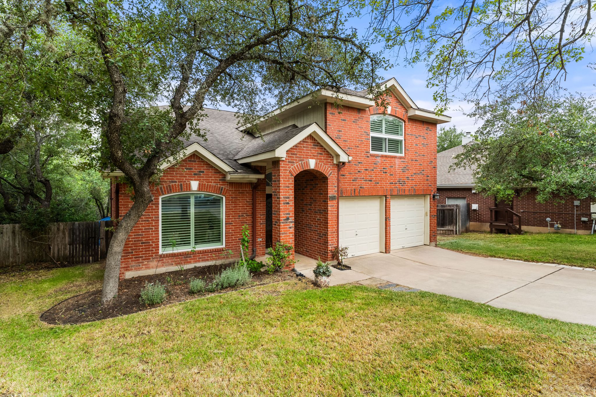 3704 Caney Creek Road Austin, TX 78732 - Photo 3 of 40 Brick facade home offers two-car garage and mature trees providing natural shade.