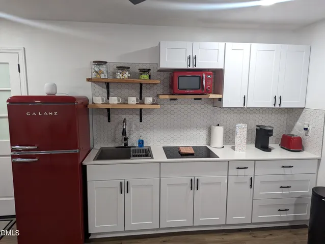 a kitchen with cabinets appliances and a window