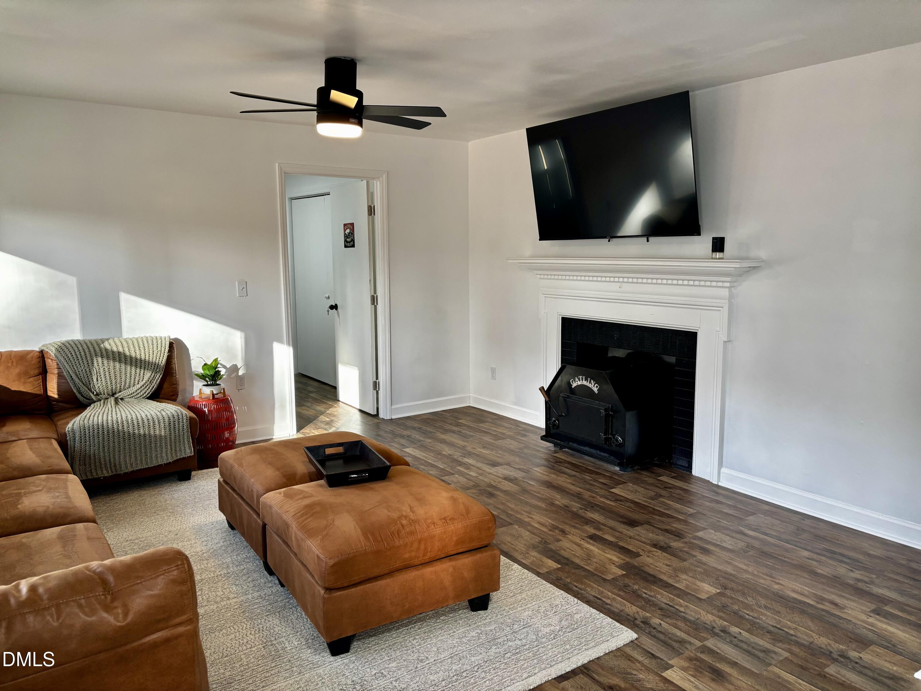4816 Whitehall Avenue Raleigh, NC 27604 - Photo 3 of 23 a living room with furniture a flat screen tv and a fireplace