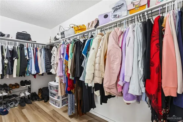 a view of walk in closet with clothes and shoes