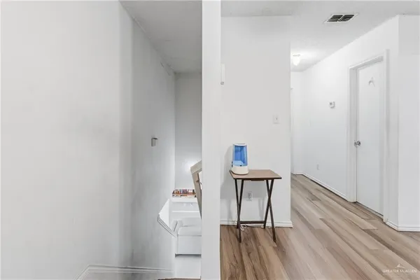 a view of a hallway with wooden floor and staircase