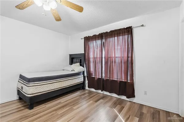 a view of a bedroom with wooden floor and windows