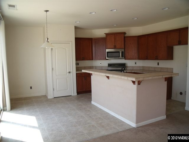 1327 Rouge River Road Fernley, NV 89408 - Photo 4 of 9 a kitchen with stainless steel appliances granite countertop a sink stove and refrigerator