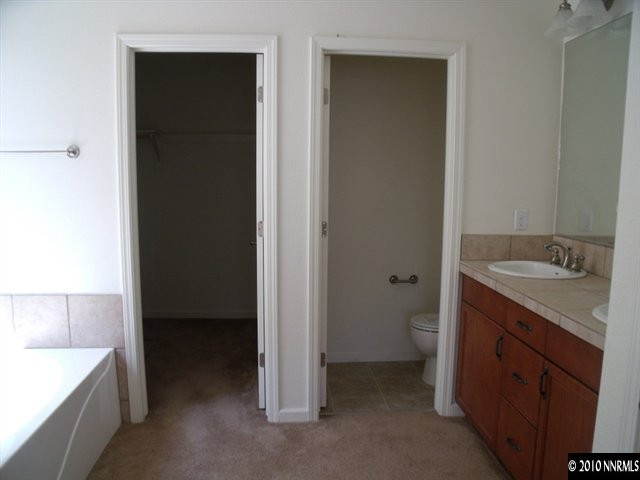 1327 Rouge River Road Fernley, NV 89408 - Photo 9 of 9 a spacious bathroom with a granite countertop sink a toilet and a bathtub