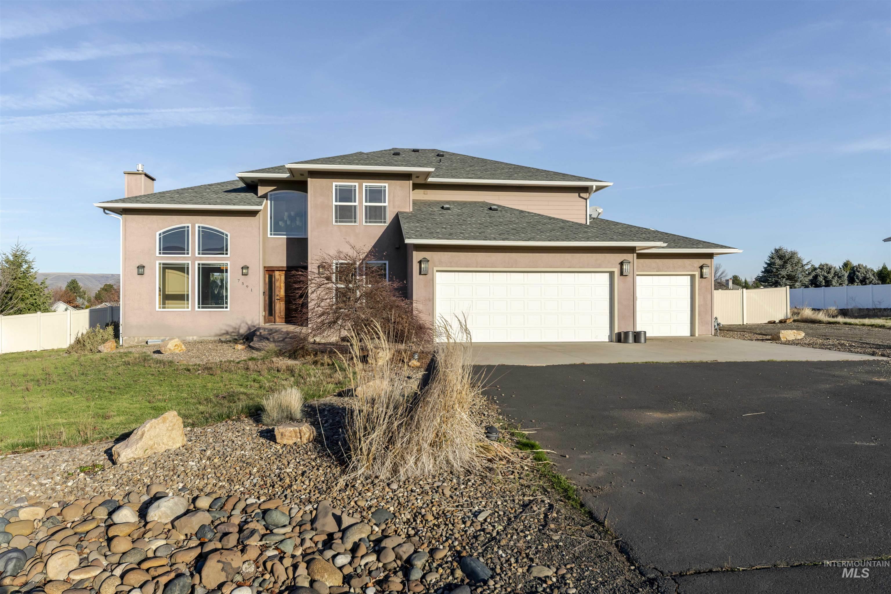 View of front of home featuring roof with shingles, driveway, stucco siding, an attached garage, and a chimney