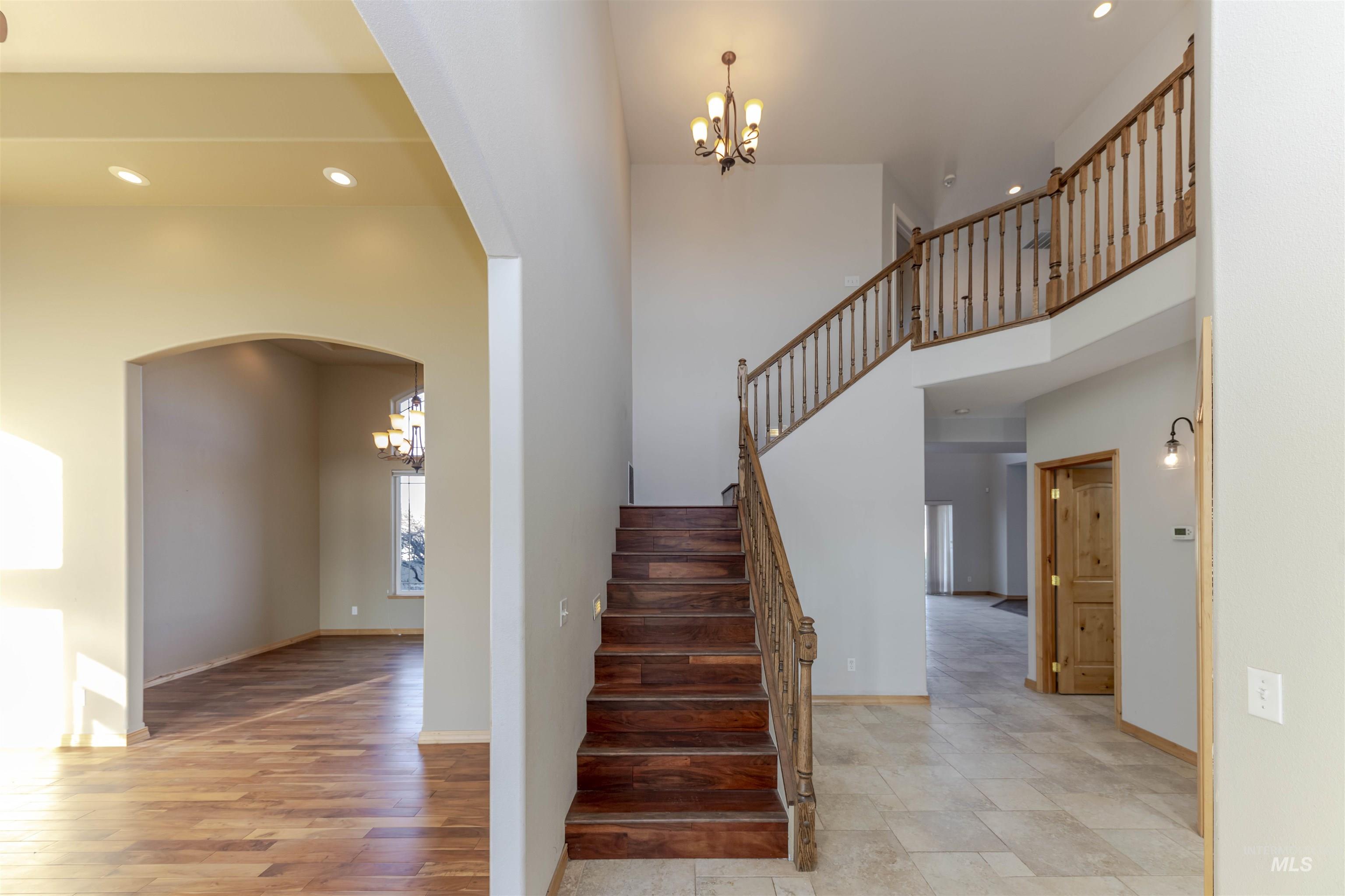7591 Pheasant Chase Drive Lewiston, ID 83501 - Photo 13 of 32 Stairs featuring a chandelier, recessed lighting, arched walkways, and a towering ceiling