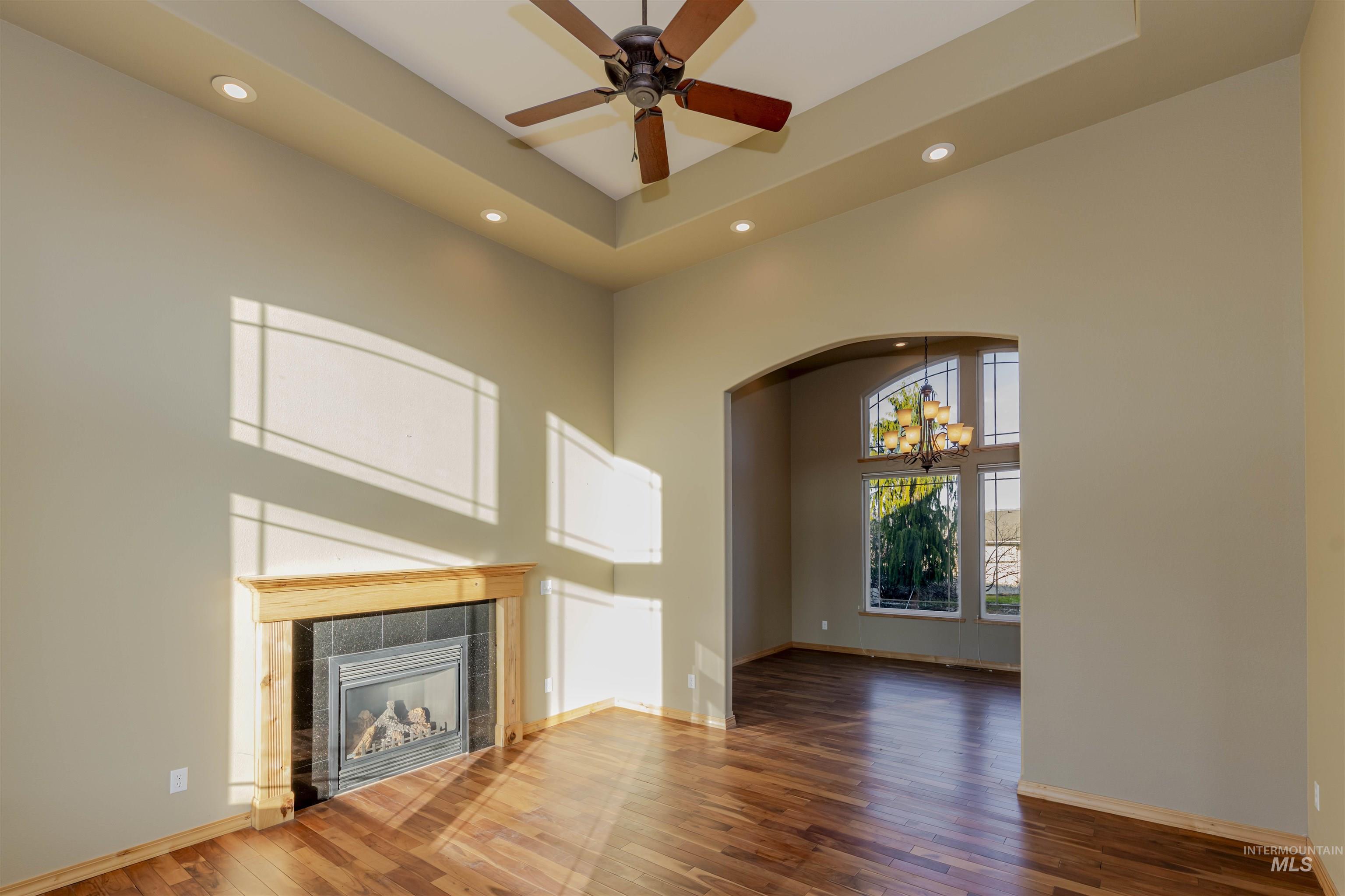 7591 Pheasant Chase Drive Lewiston, ID 83501 - Photo 2 of 32 Unfurnished living room featuring a high ceiling, a chandelier, hardwood / wood-style floors, recessed lighting, and a tile fireplace