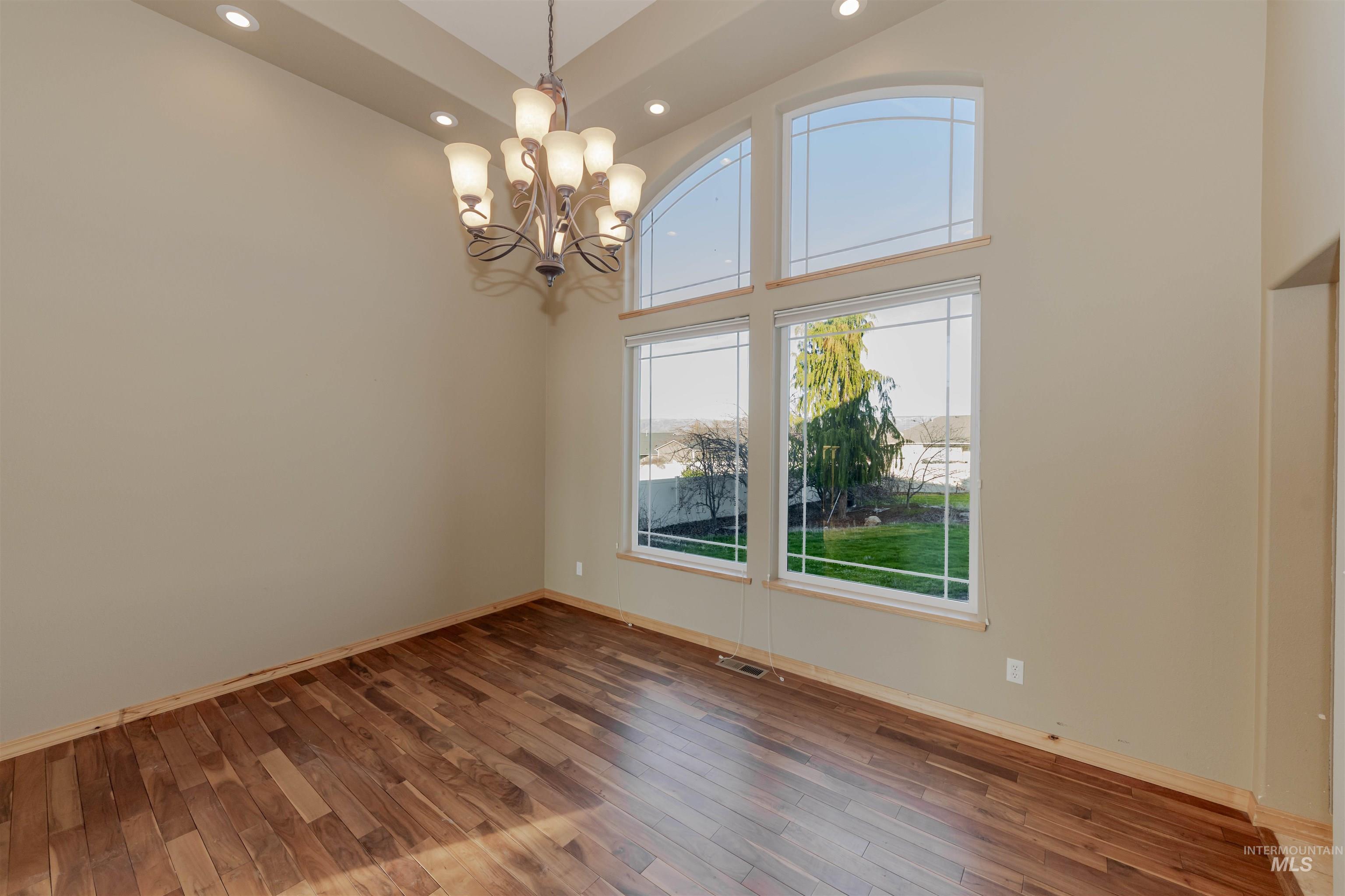 7591 Pheasant Chase Drive Lewiston, ID 83501 - Photo 5 of 32 Dining room featuring wood-type flooring, a high ceiling, a chandelier, and recessed lighting
