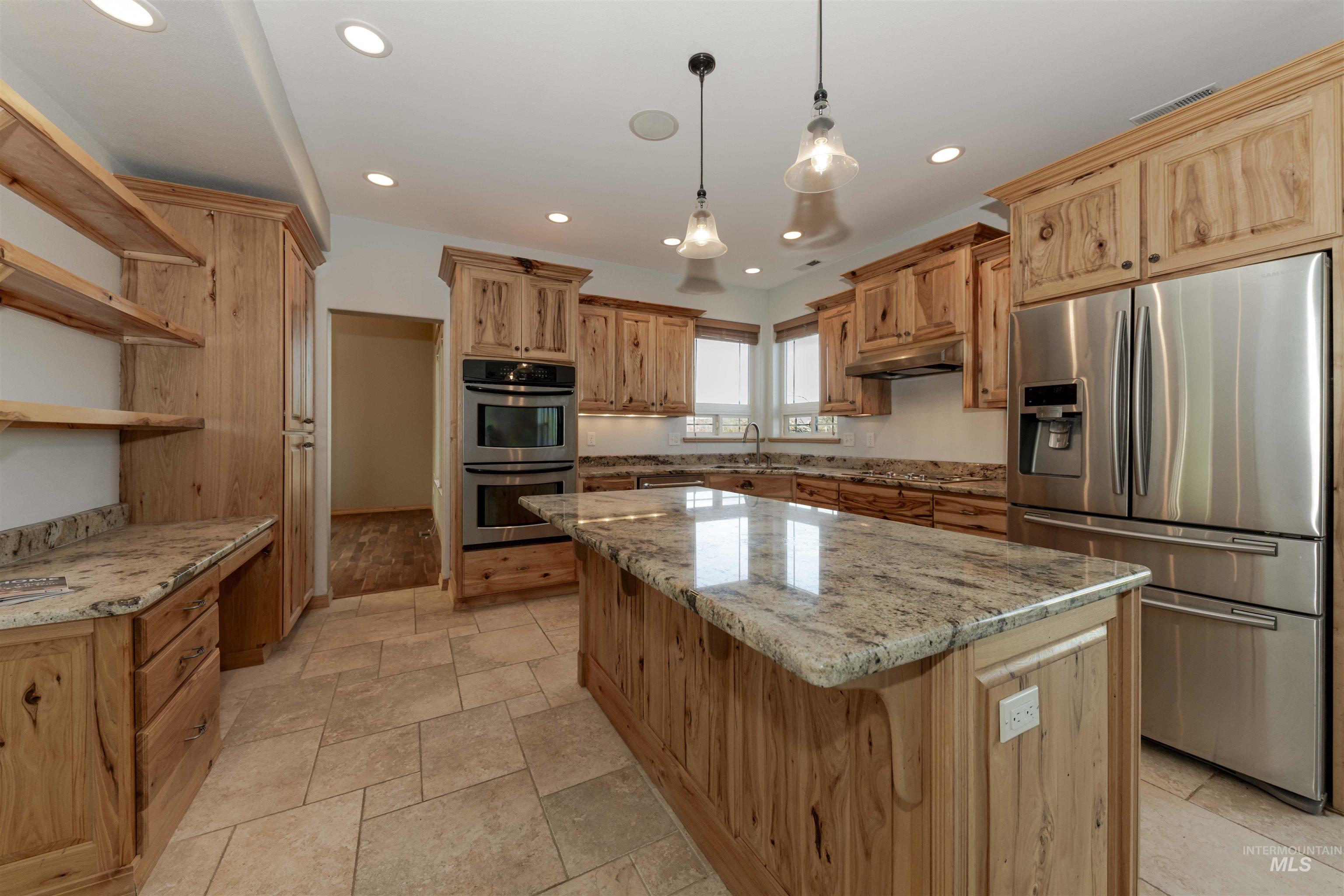 7591 Pheasant Chase Drive Lewiston, ID 83501 - Photo 6 of 32 Kitchen featuring appliances with stainless steel finishes, light stone countertops, decorative light fixtures, recessed lighting, and a kitchen island