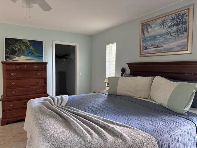 a bedroom with a bed and painting on the wall