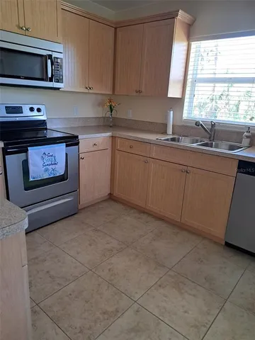 a kitchen with stainless steel appliances a sink a stove a microwave a sink and cabinets