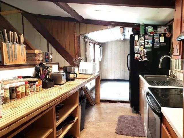 a kitchen with stainless steel appliances granite countertop a sink a stove and a refrigerator