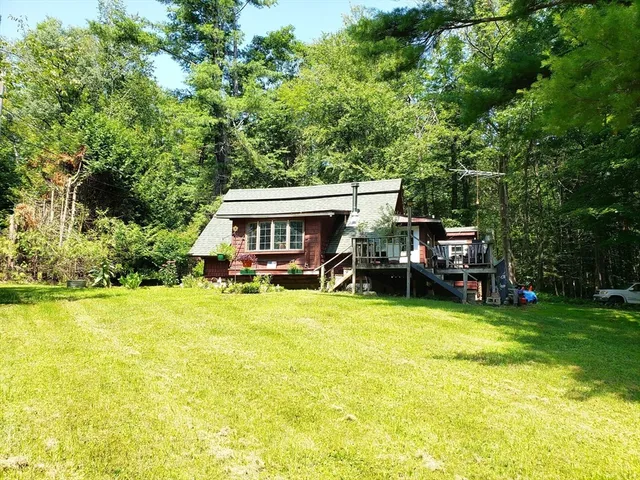 a view of a house with pool and chairs