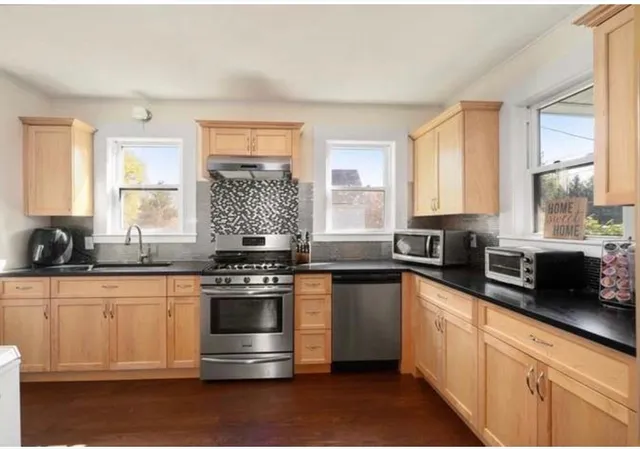 a kitchen with stainless steel appliances a stove sink and window