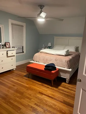 a spacious bedroom with a bed and a dresser