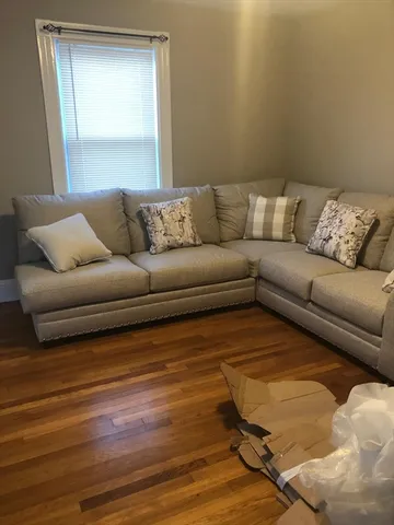 a living room with a couch and a wooden floor