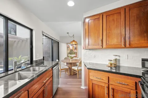 a kitchen with stainless steel appliances wooden cabinets a sink and a large window