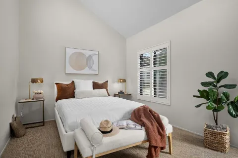 a bedroom with a bed and a potted plant