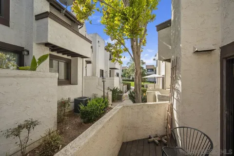 a view of a house with a cars park side of a road
