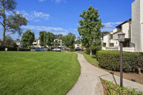 a view of a house with a big yard and large trees