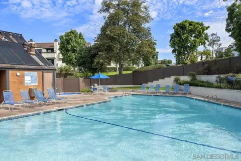 a view of backyard with swimming pool and furniture