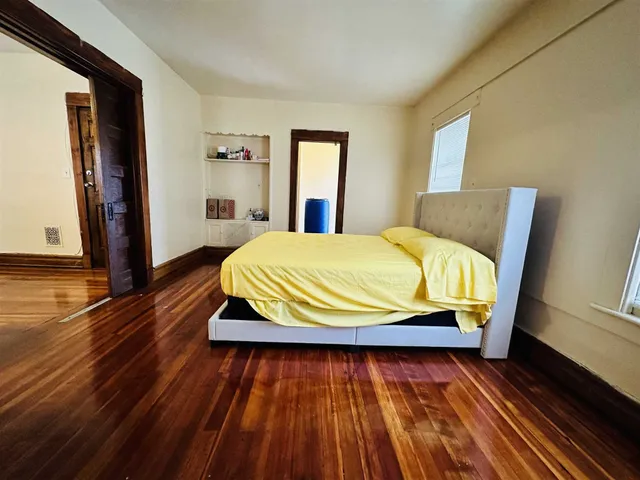 a bedroom with a bed and wooden floor