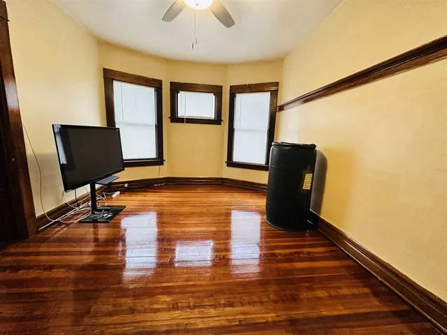 a view of empty room with wooden floor