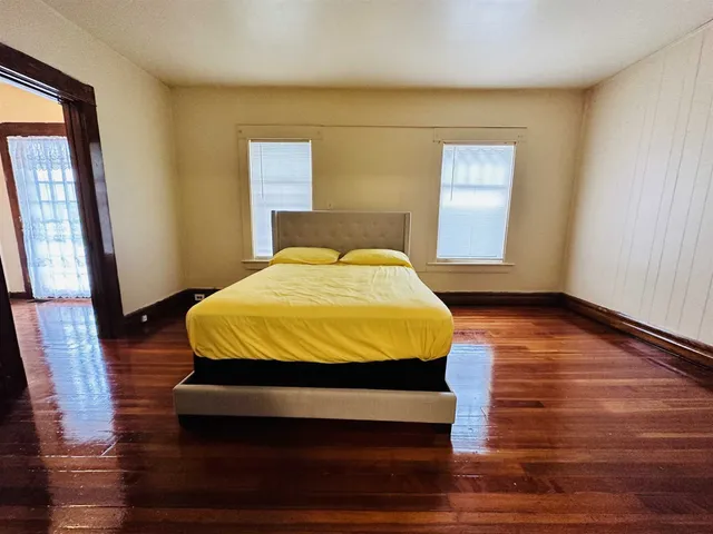 a bedroom with a bed and wooden floor