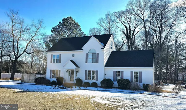 a front view of a house with a yard covered in snow