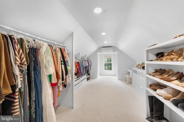 a view of walk in closet with clothes and shoes