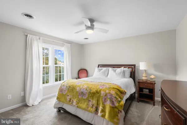 a large bed sitting in a bedroom next to a window