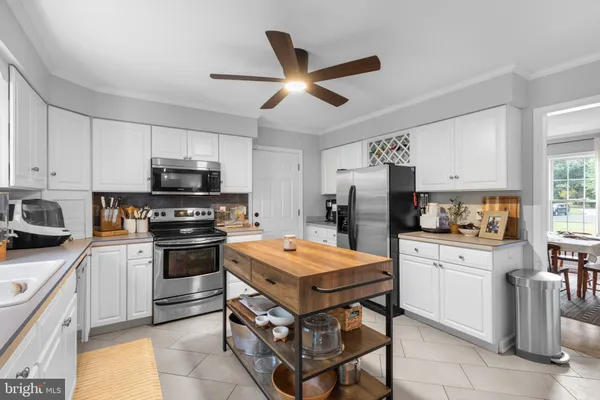 a kitchen with stainless steel appliances a stove refrigerator sink and cabinets