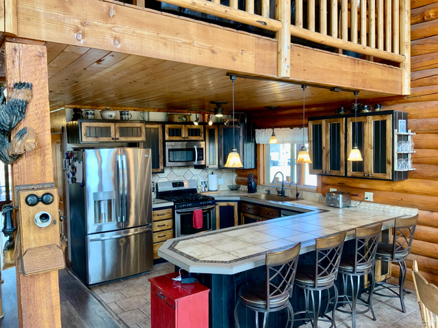 76 Highway 118 Monroe, UT 84754 - Photo 26 of 76 Kitchen with stainless steel appliances, decorative light fixtures, a kitchen breakfast bar, wooden ceiling, and a peninsula